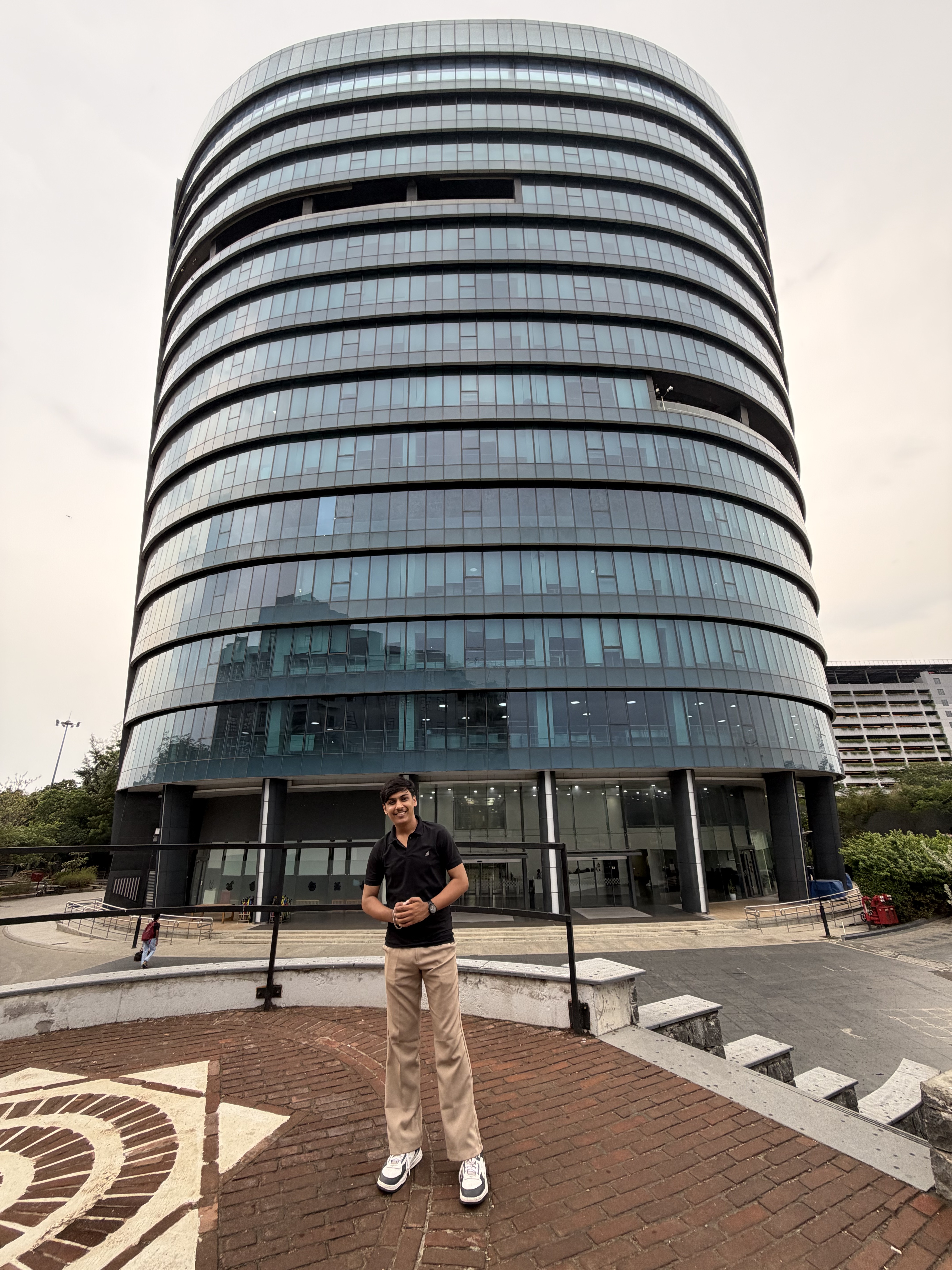 Vishal standing in front of a modern glass building